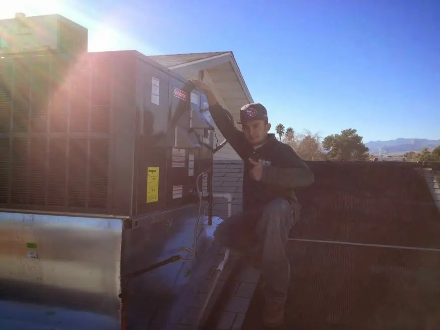 HVAC technician performing AC Tune-Up on a rooftop unit in Finley